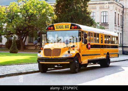 Klassischer gelber Schulbus mit rotem Stoppschild auf der Straße Stockfoto