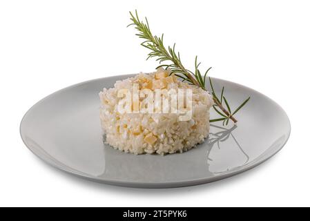 Reis mit frischem Käse und Parmesanstücken und Rosmarinzweig in einer Platte isoliert auf weiß mit Schnittpfad im Preis inbegriffen Stockfoto