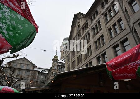 Weihnachtsmarkt im Zentrum von Zürich. Niedriger Winkel mit Umrissen von farbenfrohen Marktständen mit historischen Gebäuden. Stockfoto