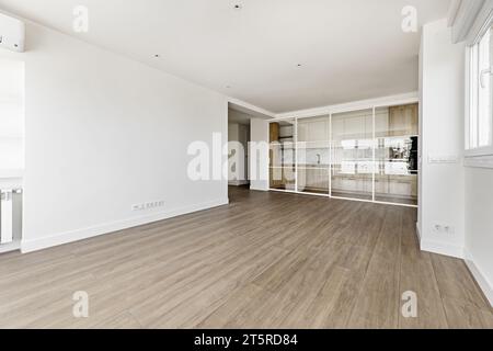 Großes leeres, modernes Wohnzimmer mit weiß lackierten Wänden und Glastrennwand Stockfoto
