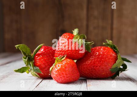 Beeren großer reifer, frischer biologischer Erdbeeren auf Holzhintergrund aus Nahaufnahme. Stockfoto