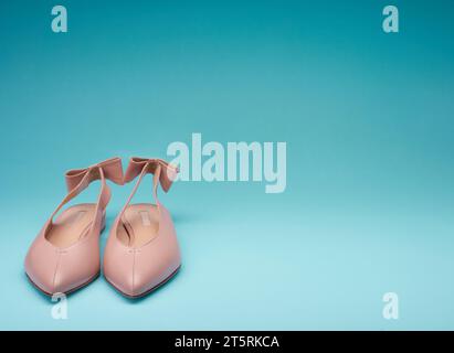 Klassische, spitz zulaufende Schuhe mit offenem Rücken, verziert mit Schleifen an den hinteren Trägern, isoliert auf einem hellen verlaufenden Hintergrund mit Kopierraum. Modisches Design Stockfoto
