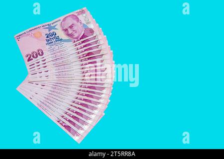 200 Türkische Liras in Viertelwerk auf blauem Hintergrund angeordnet Stockfoto