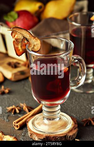 Ein Glas Glühwein mit Früchten und Gewürzen auf einem Hintergrund. Traditionelle Getränke. Festliche Getränke. Nahaufnahme. Stockfoto