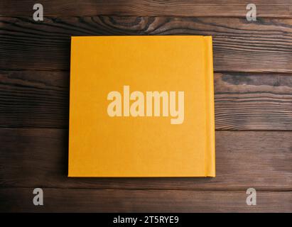 Stilvolles Buch mit hellem Hardcover aus Leder auf Holzhintergrund. Rückabdeckung, Draufsicht. Fotoalbum, Notizbuch, Tagebuch, Planer oder Sammelalbum. T Stockfoto