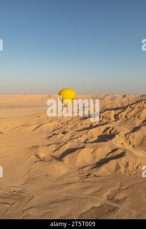 Der Heißluftballon steigt in den blauen Himmel über der Wüste und den antiken Ruinen des Tals der Könige Stockfoto