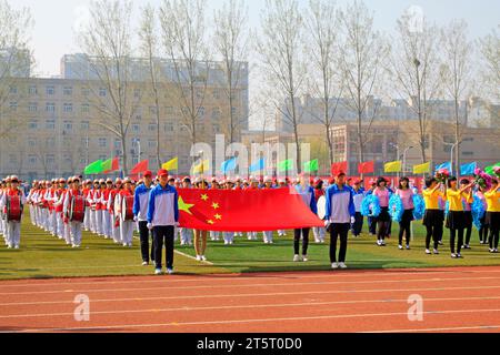 LUANNAN COUNTY - 14. APRIL: China-Flagge und Fahnenträger beim Leichtathletik-Treffen, 14. April 2015, Luannan County, Provinz Hebei, China Stockfoto