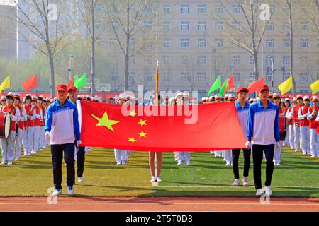 LUANNAN COUNTY - 14. APRIL: China-Flagge und Fahnenträger beim Leichtathletik-Treffen, 14. April 2015, Luannan County, Provinz Hebei, China Stockfoto