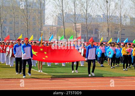 LUANNAN COUNTY - 14. APRIL: China-Flagge und Fahnenträger beim Leichtathletik-Treffen, 14. April 2015, Luannan County, Provinz Hebei, China Stockfoto