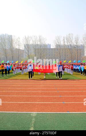 LUANNAN COUNTY - 14. APRIL: China-Flagge und Fahnenträger beim Leichtathletik-Treffen, 14. April 2015, Luannan County, Provinz Hebei, China Stockfoto