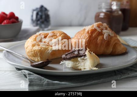 Leckere Croissants mit Mandelflocken und Schokolade auf dem Tisch, Nahaufnahme Stockfoto