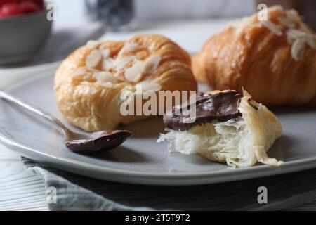 Leckere Croissants mit Mandelflocken und Schokolade auf dem Tisch, Nahaufnahme Stockfoto