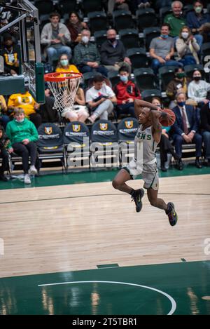 College-Basketballspieler fahren zum Rand für einen Layup während der NCAA-Action, aufgenommen mit scharfen Details und dynamischer Energie in der Halle. Stockfoto