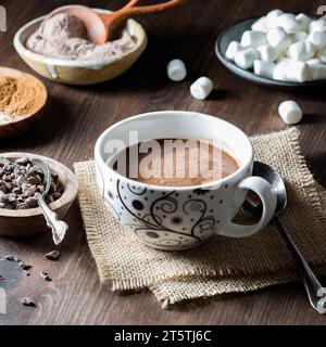 Eine Tasse hausgemachter heißer Kakao mit Zutaten überall. Stockfoto