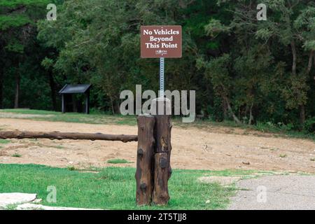 Aufschrift auf Holzplanke, keine Fahrzeuge jenseits dieses Punktes im Park, Warnschild. Stockfoto