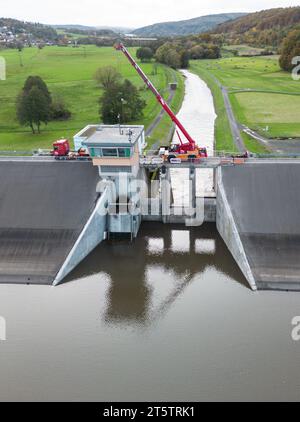 PRODUKTION - 01. November 2023, Hessen, Bad Soden-Salmünster: Ein Bagger steht auf dem Wehr des Kinzigtaler Damms (Luftaufnahme mit Drohne). Nach dem Austausch der defekten Dammtore sollte der Tank in den kommenden Monaten wieder mit Wasser gefüllt werden. (Zu dpa 'Arbeiten am Kinzig-Damm bald abgeschlossen - Staudamm kann beginnen') Foto: Boris Roessler/dpa Stockfoto