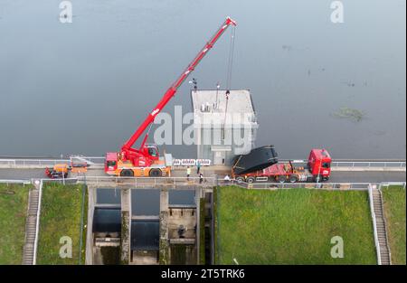 PRODUKTION - 01. November 2023, Hessen, Bad Soden-Salmünster: Ein Bagger steht auf dem Wehr des Kinzigtaler Damms (Luftaufnahme mit Drohne). Nach dem Austausch der defekten Dammtore sollte der Tank in den kommenden Monaten wieder mit Wasser gefüllt werden. (Zu dpa 'Arbeiten am Kinzig-Damm bald abgeschlossen - Staudamm kann beginnen') Foto: Boris Roessler/dpa Stockfoto