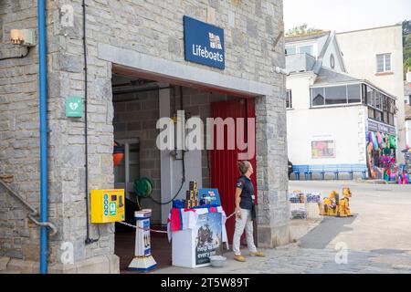 RNLI Rettungsboote Büro in Lyme Regis Dorset, Frau, die RNLI und Fundraising fördert, England, Großbritannien, 2023 Stockfoto