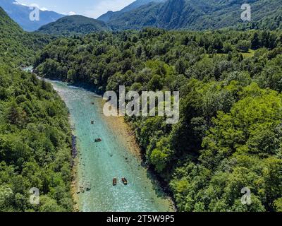 Soca-Tal, Slowenien - aus der Vogelperspektive auf den smaragdgrünen Alpenfluss Soca mit Kajaks und Rafting-Booten, die an einem hellen, sonnigen Sommertag den Fluss hinunter fahren Stockfoto