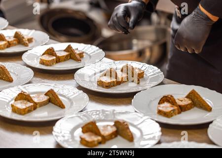 Koch plattiert geröstete Brotscheiben und Hackfleisch auf weißen Tellern. Stockfoto