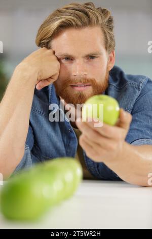 Grüner Apfel in der Hand eines Mannes Stockfoto