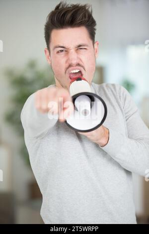 Mann mit Megaphon, der nach vorne zeigt Stockfoto