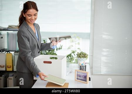 Lächelnd förderte die junge Geschäftsfrau, die Planer am Schreibtisch ausführte Stockfoto