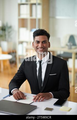 Porträt eines glücklichen, erfolgreichen indischen Geschäftsmannes, der am Schreibtisch arbeitet Stockfoto