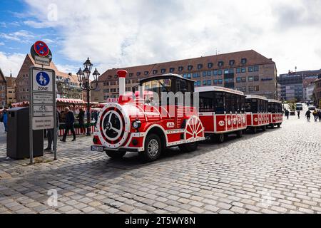 Nürnberg, Deutschland - 25. Oktober 2023: Roter Touristenwagen nimmt Passagiere mit auf eine Besichtigungstour durch die berühmten Straßen Nürnbergs. Hauptbahnhof Stockfoto