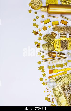 Rahmenrand aus verschiedenen goldenen Kunstwerken und Kunsthandwerk-Vorräten. Helle goldene Objekte für Kreativität und Kunstprojekte von oben. Stockfoto