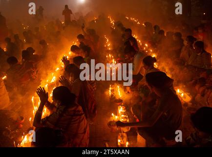 Narayanganj, Bangladesch. November 2023. Hunderte hinduistische Gläubige versammeln sich vor dem Shri Shri Loknath Brahmachari Ashram-Tempel zum Rakher-Upobash, einem religiösen Fastfest namens Kartik Brati, in Barodi, Narayanganj, Bangladesch. Sie sitzen vor Kerzenlichtern (lokal Prodip genannt), fasten und beten ernsthaft zu den Göttern für ihre Gunst während des Rituals. Das Festival findet an jedem Samstag und Dienstag in den letzten 15 Tagen des Bangali-Monats statt – „Kartik. Quelle: Joy Saha/Alamy Live News Stockfoto