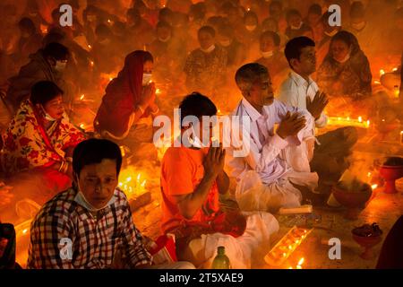 Narayanganj, Bangladesch. November 2023. Hunderte hinduistische Gläubige versammeln sich vor dem Shri Shri Loknath Brahmachari Ashram-Tempel zum Rakher-Upobash, einem religiösen Fastfest namens Kartik Brati, in Barodi, Narayanganj, Bangladesch. Sie sitzen vor Kerzenlichtern (lokal Prodip genannt), fasten und beten ernsthaft zu den Göttern für ihre Gunst während des Rituals. Das Festival findet an jedem Samstag und Dienstag in den letzten 15 Tagen des Bangali-Monats statt – „Kartik. Quelle: Joy Saha/Alamy Live News Stockfoto