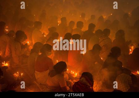 Narayanganj, Bangladesch. November 2023. Hunderte hinduistische Gläubige versammeln sich vor dem Shri Shri Loknath Brahmachari Ashram-Tempel zum Rakher-Upobash, einem religiösen Fastfest namens Kartik Brati, in Barodi, Narayanganj, Bangladesch. Sie sitzen vor Kerzenlichtern (lokal Prodip genannt), fasten und beten ernsthaft zu den Göttern für ihre Gunst während des Rituals. Das Festival findet an jedem Samstag und Dienstag in den letzten 15 Tagen des Bangali-Monats statt – „Kartik. Quelle: Joy Saha/Alamy Live News Stockfoto