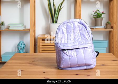 Stilvoller Schulrucksack auf Holztisch im Wohnzimmer Stockfoto