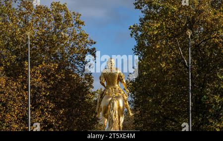 Dresden, Deutschland. November 2023. Am Morgen scheint die Sonne auf den „Goldenen Reiter“, die überlebensgroße Reiterstatue des sächsischen Kurfürsten Augustus des Starken (1670-1733) aus dem 18. Jahrhundert. Die herbstfarbenen Blätter der Bäume auf der Hauptstraße sind im Hintergrund zu sehen. Robert Michael/dpa/Alamy Live News Stockfoto