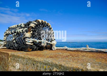 Frankreich, Omonville-la-Rogue, Le Hable, 02.09.2023: Eine alte Hummerreuse liegt auf der Hafenmauer des kleinen Fischereihafens Le Hable in Omonville Stockfoto