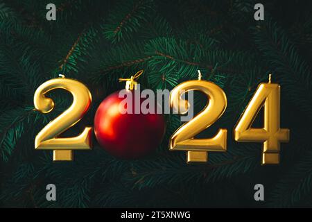 Festlicher Hintergrund Frohes neues Jahr 2024. Goldkerzen auf dem Hintergrund von Tannenzweigen. Stockfoto