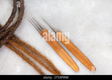 Haarhäkelnadeln und dekorative Perlen für Dreadlocks und Zöpfe auf weiß Stockfoto