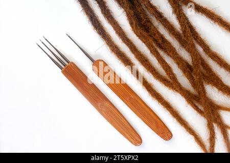 Haarhäkelnadeln und dekorative Perlen für Dreadlocks und Zöpfe auf weiß Stockfoto