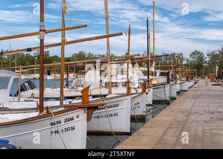 Portocolom, Spanien; 06. november 2023: Allgemeiner Blick auf die malerische mallorquinische Stadt Portocolom und ihren berühmten Bootssteg, bei Sonnenaufgang an einer Herbstzeit Stockfoto