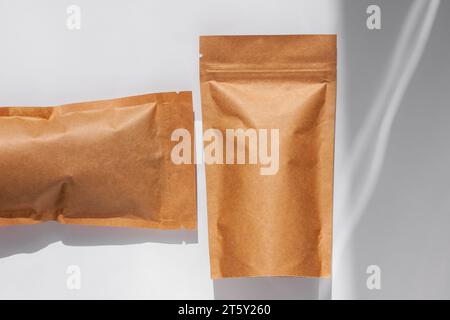 Braune Kraftpapierbeutel mit Blick auf Kaffeebohnen von oben mit Schatten isoliert auf weißem Hintergrund. Vorlagenmodell für Verpackungen für Lebensmittel und Waren. Packen Stockfoto