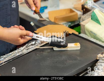 Halloumi-Spieße mit gebratenem Käse auf der Pfanne auf dem Straßenmarkt. Stockfoto