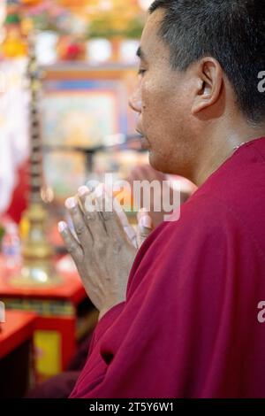 Ein frommer buddhistischer Mönch aus Nepal betet und meditiert mit gefesselten Händen. Im Sherpa Kyidug Tempel in New York City. Stockfoto