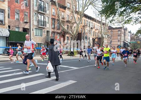 Ein orthodoxer jüdischer Mann überquert die Straße und vermeidet die Anzahl der Läufer beim New York Marathon 2023. In Williamsburg, Brooklyn Stockfoto