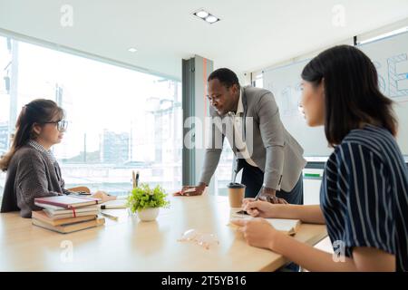 Positiv freundlicher Afro-amerikanischer Englischlehrer, der Sprachkurse für interessierte Erwachsene verschiedener Altersgruppen und Nationalitäten anbietet Stockfoto