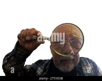 Mann, der durch eine handgehaltene Lupe schaut und auch Brille trägt, ein Auge geschlossen, Nahaufnahme, Inspektion oder Suche, Augen sind vergrößert. Isola Stockfoto