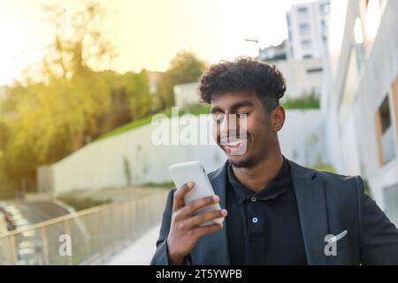 Porträt eines lächelnden arabischen Geschäftsmannes, der morgens auf der Straße telefoniert Stockfoto