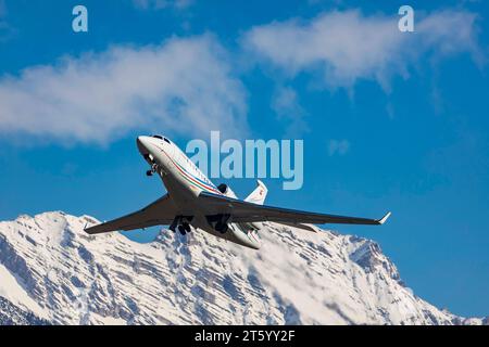 Flugzeug der Fluggesellschaft Palmali Air startet am Flughafen Innsbruck Kranebitten, Dassault Falcon 7X. Schneebedeckte Berge der Alpen, Innsbruck Stockfoto