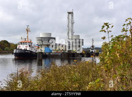 Schlepper mit Ponton mit Offshore-Installation im Kieler Kanal, Schleswig-Holstein, Deutschland Stockfoto