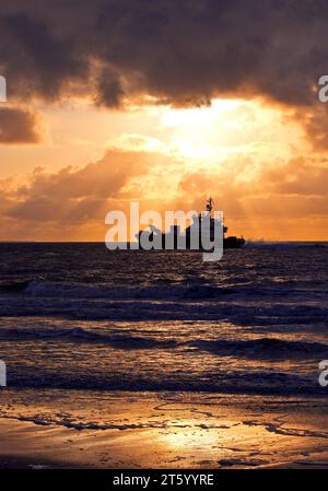 See bei Sonnenuntergang mit dem Offshore-Versorgungsschiff FARRA CLIONA, Nordsee, Norderney Island, Ostfriesland, Niedersachsen, Deutschland Stockfoto